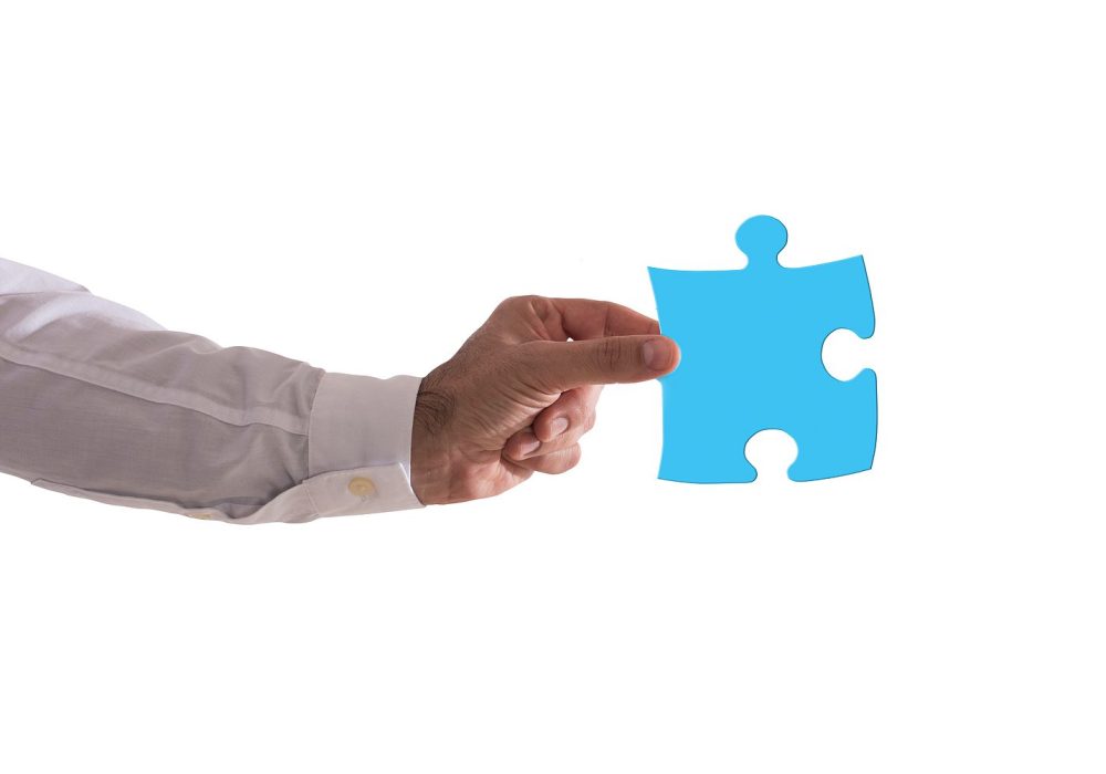 Isolated businessman holds a piace of puzzle. Concept teamwork, partnership, integration